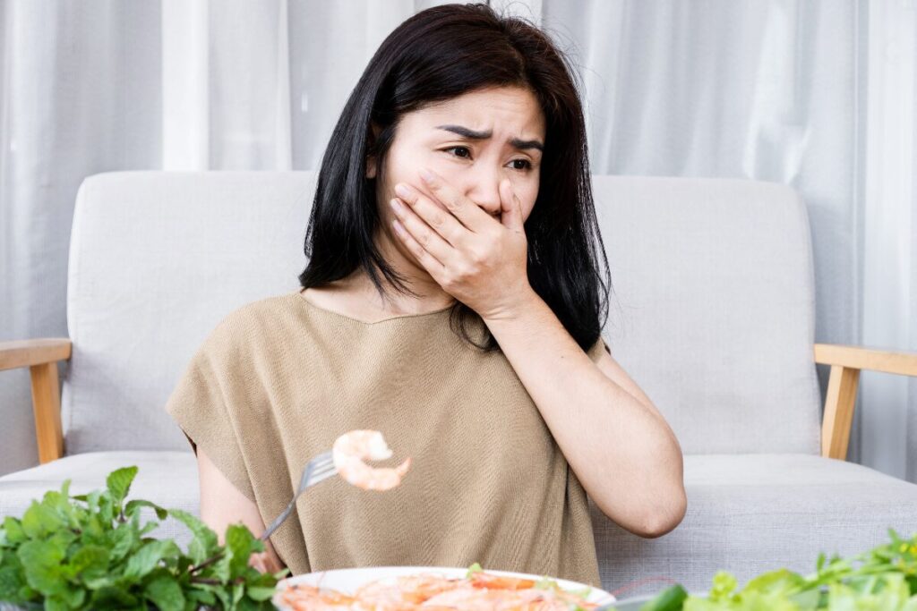 A lady having an allergic reaction to shrimp (shellfish).