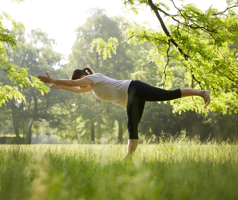 A lady doing yoga, barefoot outside which will help to reduce stress. 