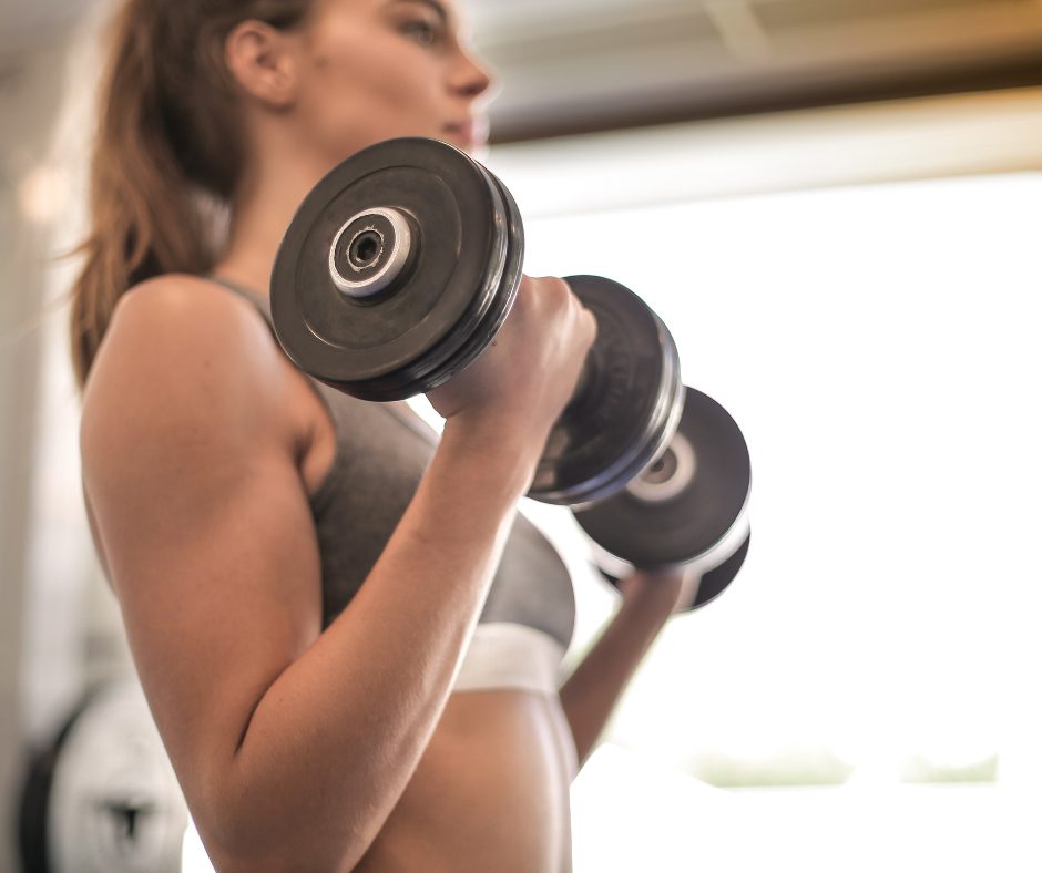 A woman lifting weight, incorporating resistance training into her routine.